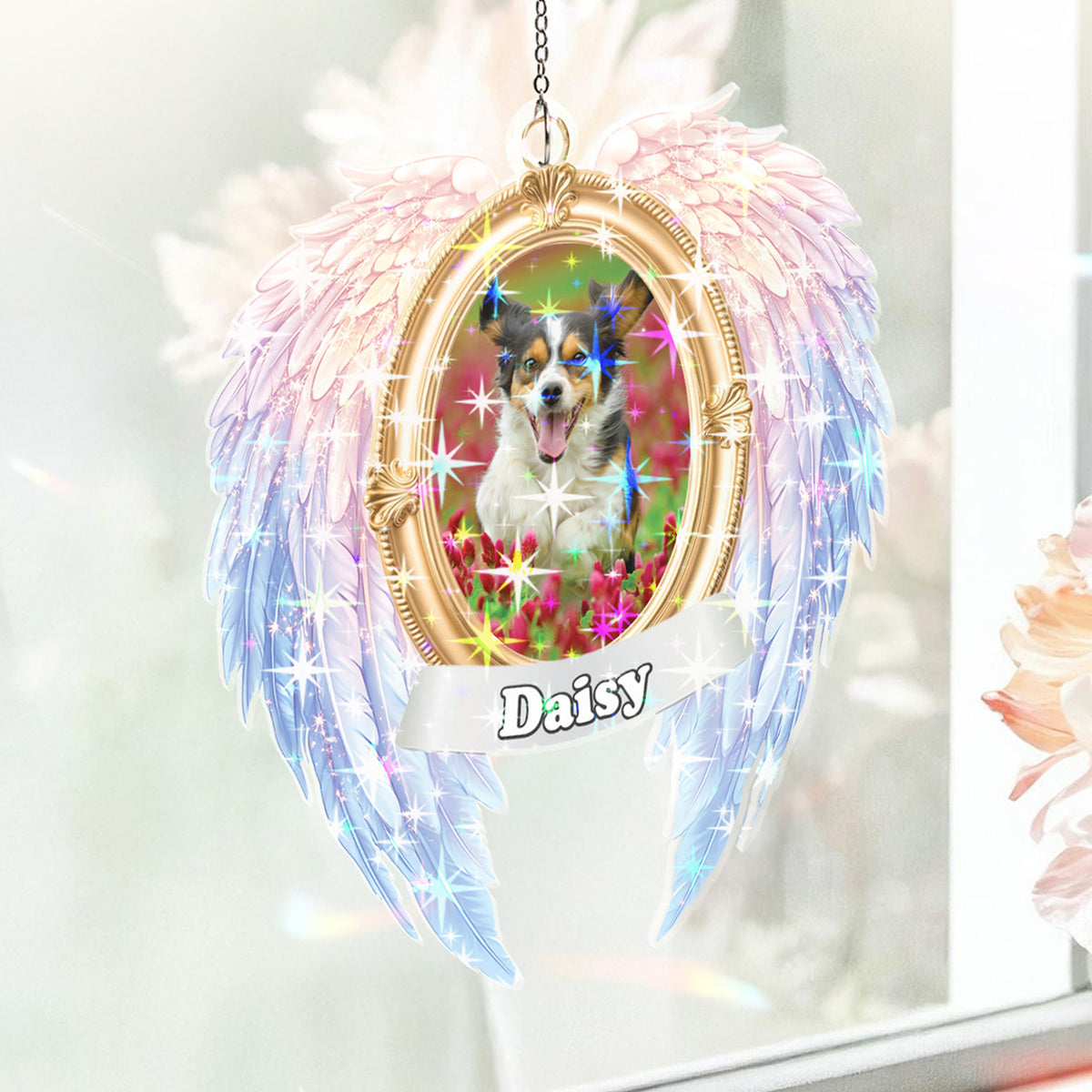 Decorative angel wing ornament with a dog photo and name 'Daisy' on a blurred floral background